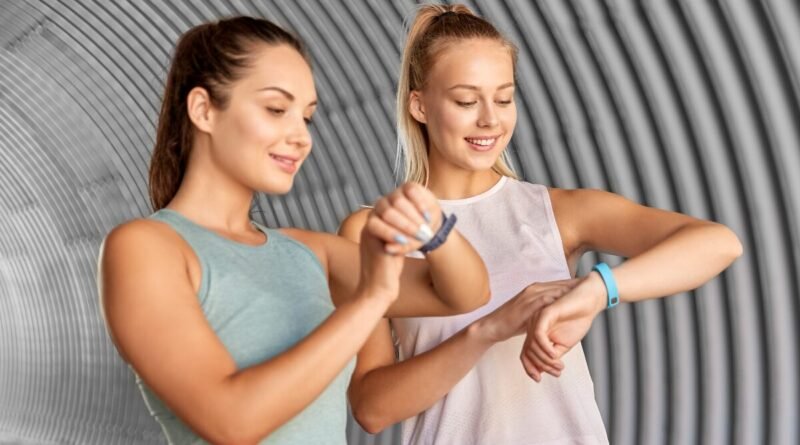 two women looking at their fitness tracker